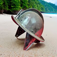 morion helmet on beach with jungle in background