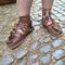 feet in roman sandals on cobblestone